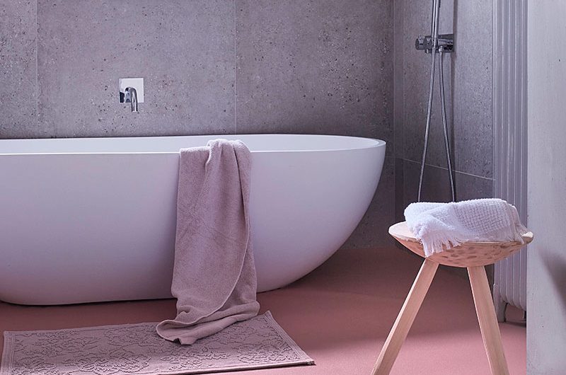 Family bathroom ideas with pink vinyl flooring and grey cement walls