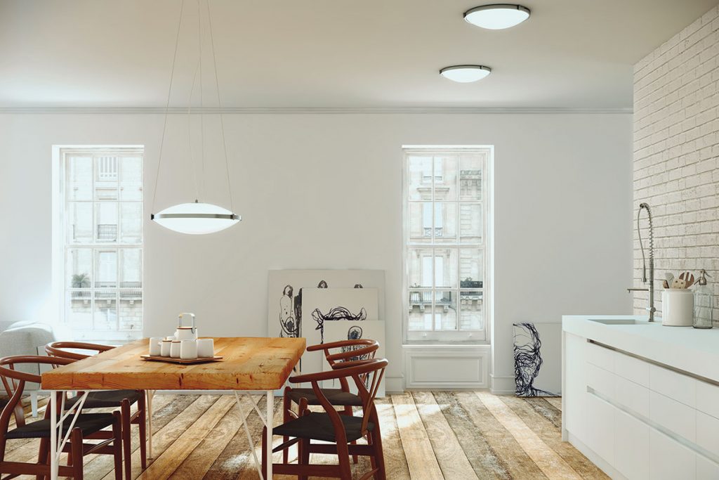 a wooden dining table with wooden chairs around it in a room with sash windows and stripped oiled floorboards to illustrate a feature on kitchen must-haves for entertaining