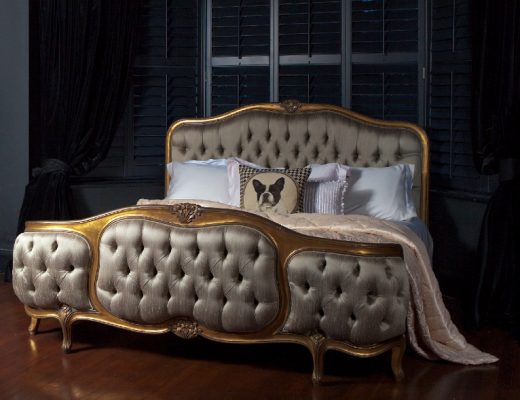 a gold four-poster Chesterfield bed from the French Bedroom Company on a dark red carpet