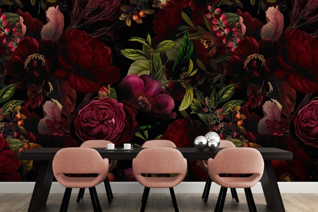 bright pink and green floral wallpaper behind a black table with pink chairs