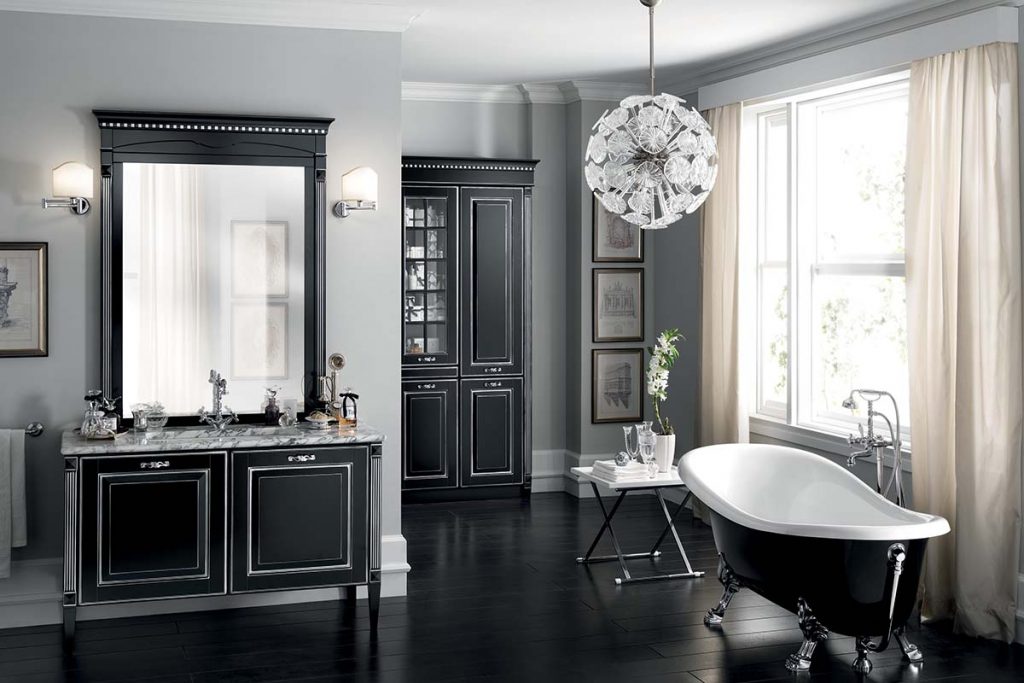 a black maximalist bathroom featuring a roll top bath, a chandelier and black Shaker cabinetry