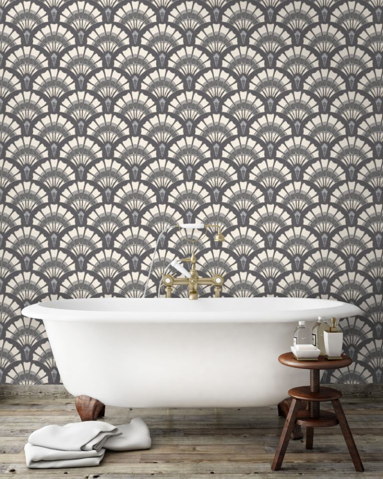 an Art Deco bathroom featuring charcoal wallpaper behind a white freestanding roll top bath