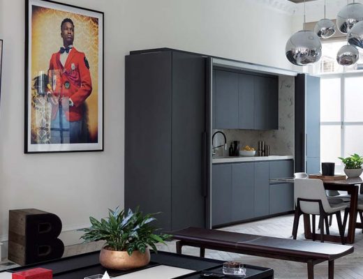 a hidden kitchen featuring matt black bespoke cabinetry