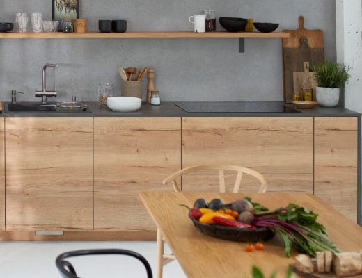 a handleless wooden kitchen with vegetables and black crockery on display
