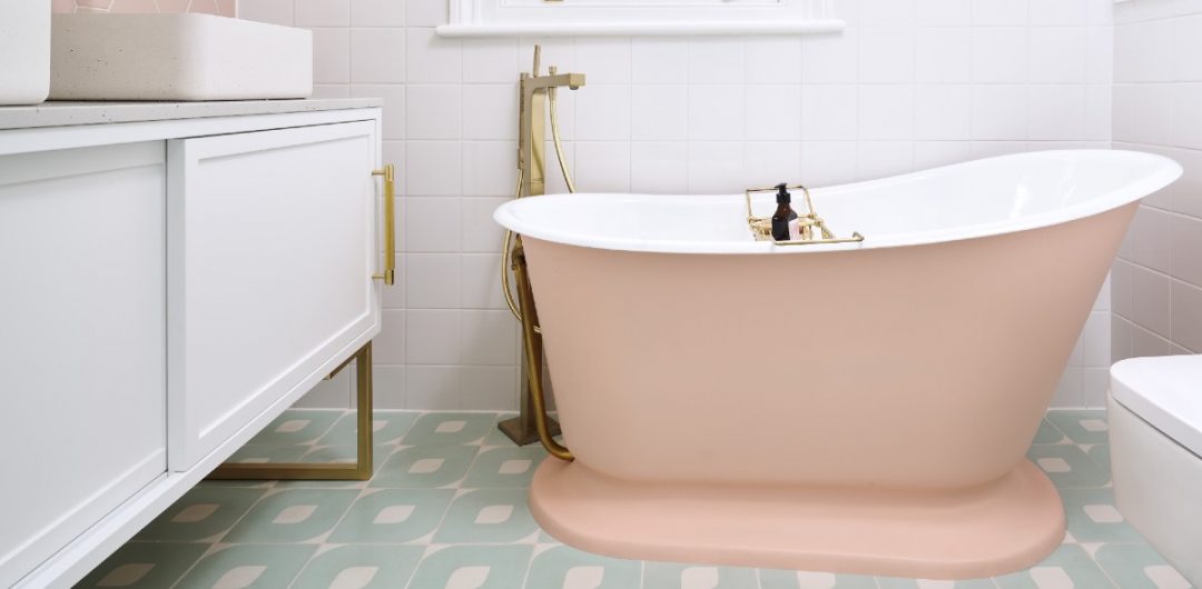 a pink double-ended bath in a traditional bathroom with brass fittings