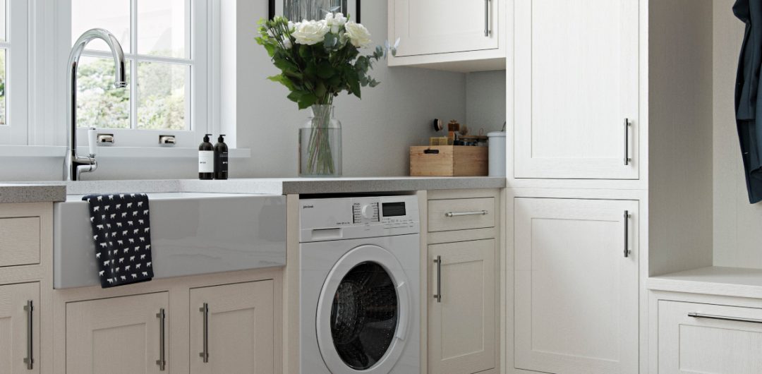 a utility room featuring pale cream shaker cabinetry with silver handles, a washing machine, and a vase of white flowers on top