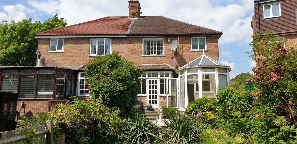 the front of a house with a glass conservatory