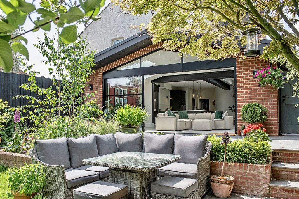 an outside space with a dining set and a kitchen extension overlooking it