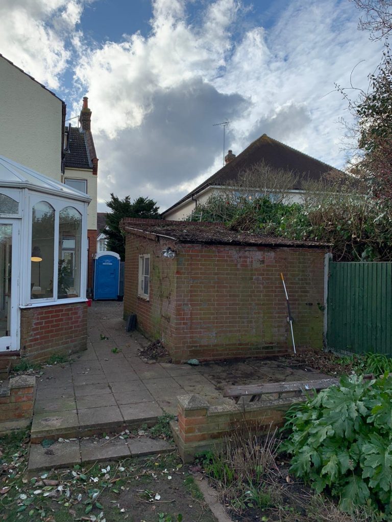 a back garden with a brick shed