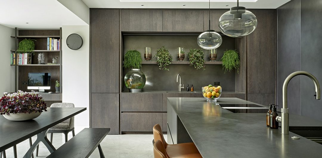 an open plan kitchen in dark wood designed by an interior designer