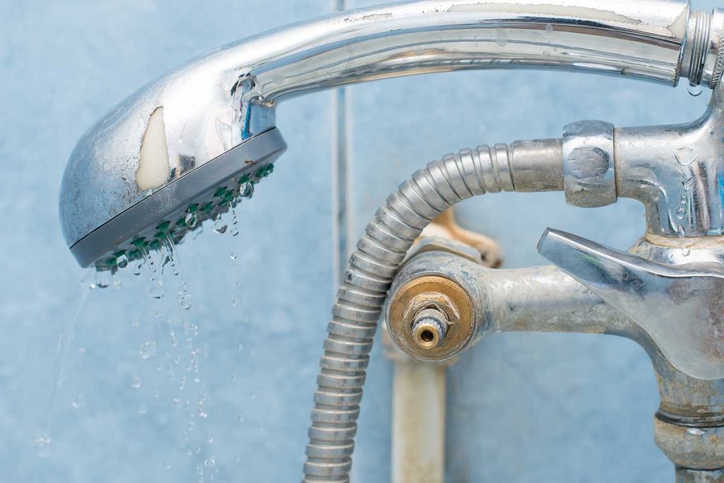 a showerhead with calcium deposits on